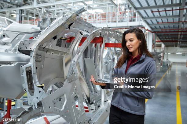 ingeniero de mantenimiento usando laptop por el chasis del coche - vehículo de motor fotografías e imágenes de stock