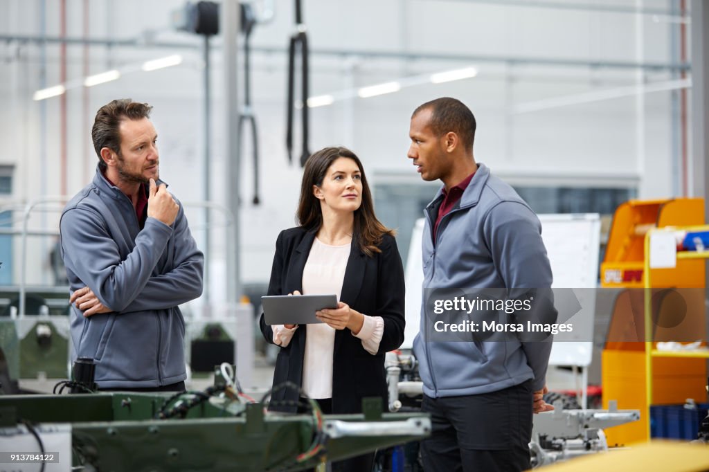 Professionals discussing in car factory