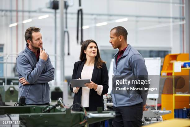professionals discussing in car factory - repairing imagens e fotografias de stock