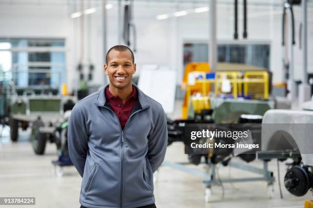 hombre ingeniero sonriendo en industria de automóvil - african male portrait fotografías e imágenes de stock