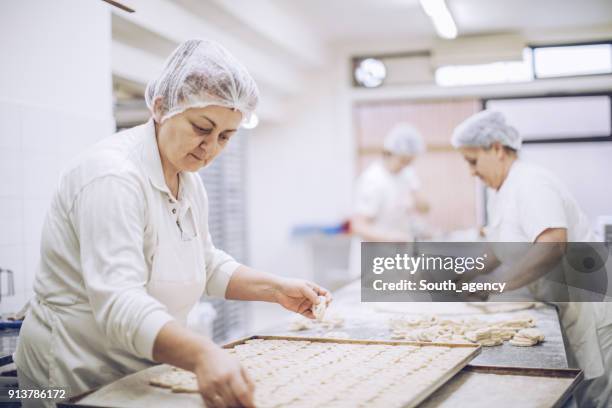 travailler dur, dans la boulangerie - boulangerie industrielle photos et images de collection