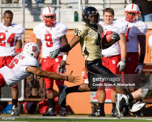 Josh Bush of the Wake Forest Demon Deacons returns an interception 61-yards against the North Carolina State Wolfpack at BB&T Field on October 3,...