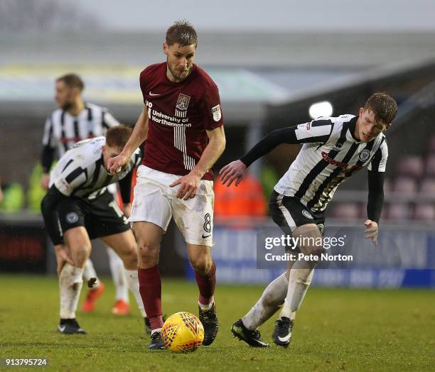 Sam Foley of Northampton Town looks to play the ball watched by Andy Cannon of Rochdale during the Sky Bet League One match between Northampton Town...