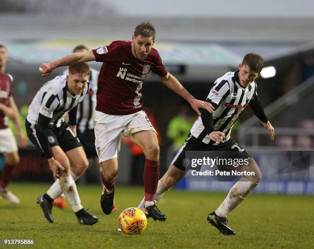 Sam Foley of Northampton Town looks to play the ball watched by Andy Cannon of Rochdale during the Sky Bet League One match between Northampton Town...