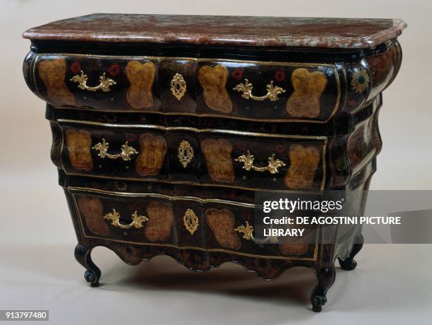 Commode with three drawers, inlaid wood and golden handles. France, early 18th century.