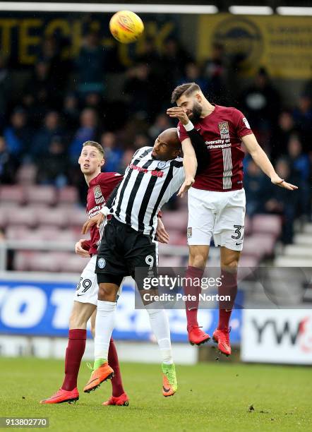 Calvin Andrew of Rochdale contests the ball with Jordan Turnbull and Joe Bunney of Northampton Town during the Sky Bet League One match between...