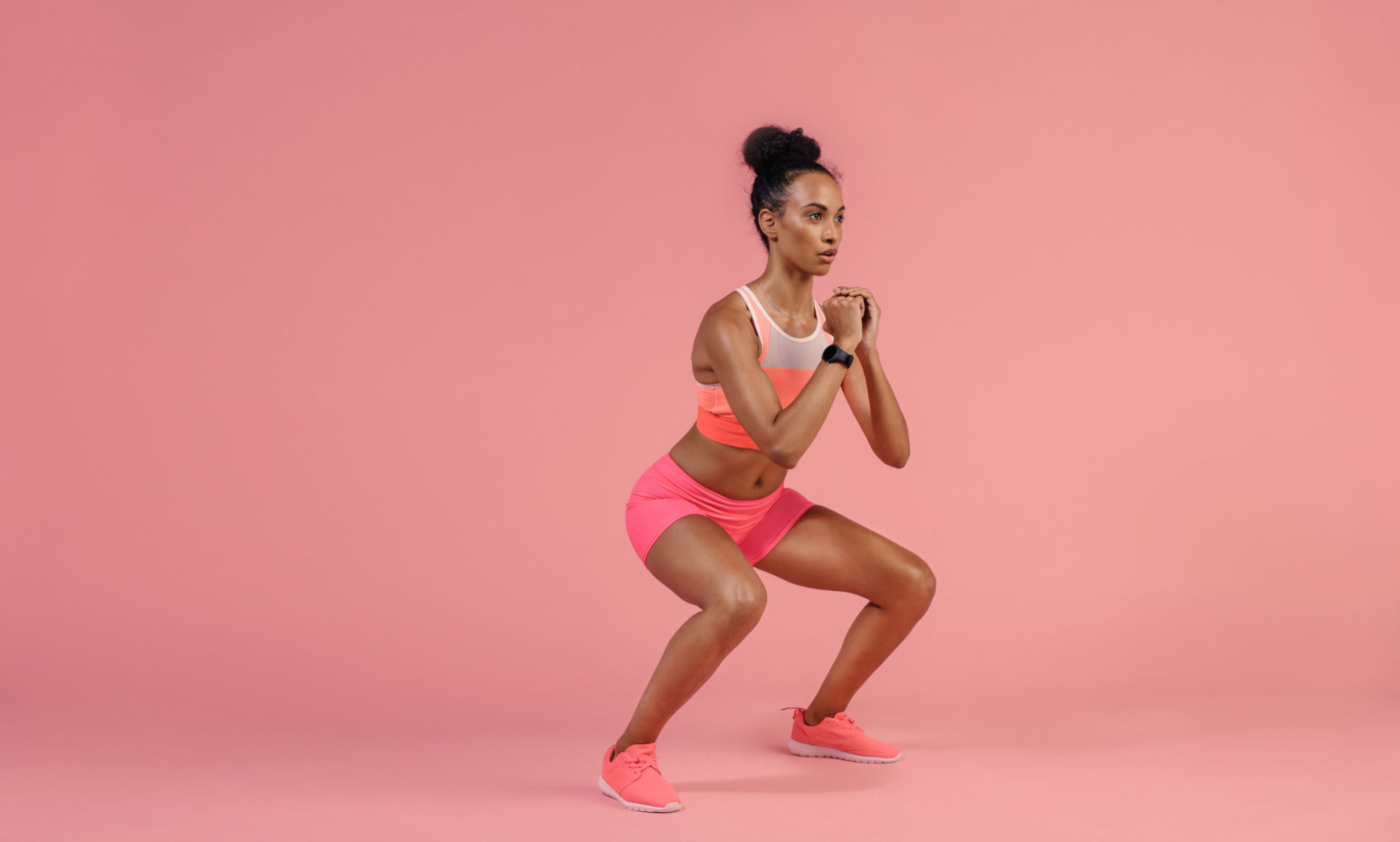 Sporty woman practicing squat exercise Sporty woman practicing squat exercise