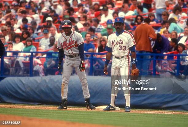 Eddie Murray of the New York Mets holds Deion Sanders of the Atlanta Braves on first during an MLB game on May 30, 1992 at Shea Stadium in Flushing,...