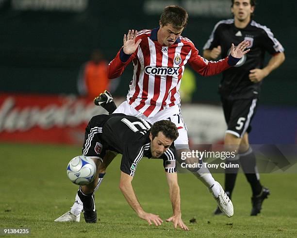 Ben Olsen of D.C. United is tackled from behind by Justin Braun of Chivas USA during an MLS match at RFK Stadium on October 3, 2009 in Washington,...