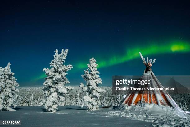 Aurora Borealis, or Northern Lights shine over a forest on February 01,2018 at Saariselka, Finland.