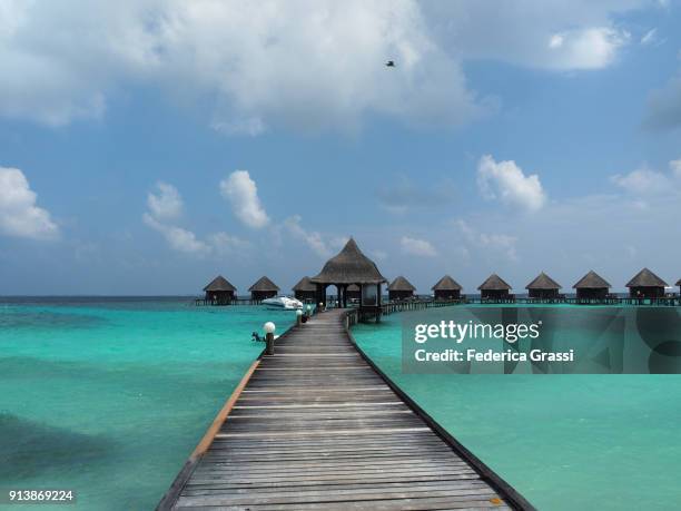 elevated walkway and overwater bungalows - thatched hut stock pictures, royalty-free photos & images