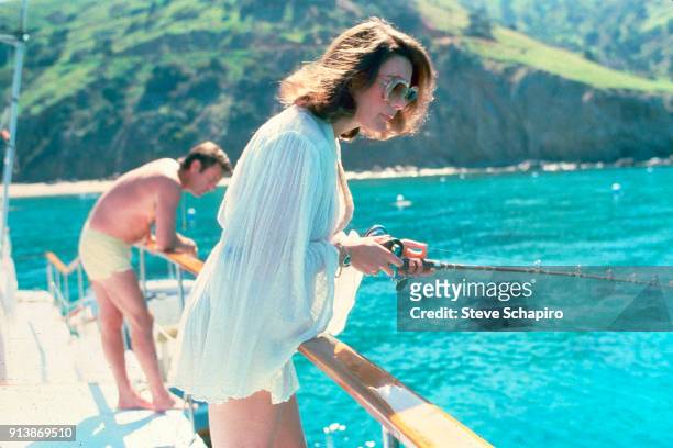 View of married American actors Natalie Wood , with a fishing rod, and Robert Wagner on their yacht, the 'Splendour,' October 8, 1976.