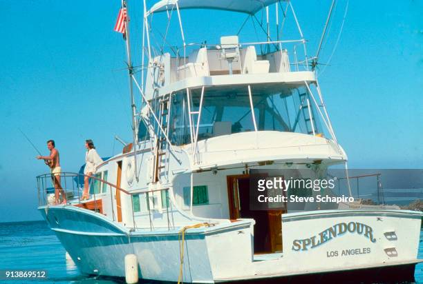 View of married American actors Robert Wagner, with a fishing rod, and Natalie Wood on their yacht, the 'Splendour,' October 8, 1976.