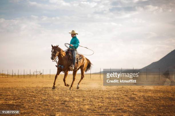 cowboy paardrijden en abseilen in de vroege ochtend op een ranch utah - cowboy stockfoto's en -beelden