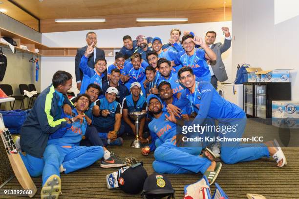 Head Coach Rahul Dravid of India and his players pose for a team photo with the trophy in the dressing room after the win in the ICC U19 Cricket...