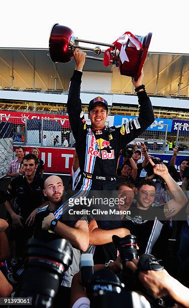 Sebastian Vettel of Germany and Red Bull Racing celebrates with team mates in the pitlane after winning the Japanese Formula One Grand Prix at Suzuka...
