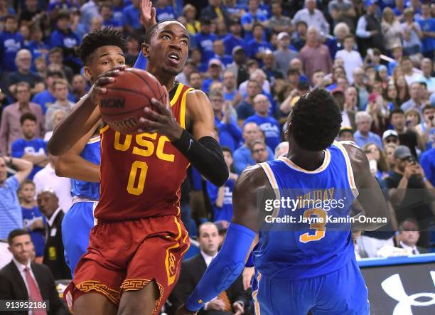 Jaylen Hands and Aaron Holiday of the UCLA Bruins pressure Shaqquan Aaron of the USC Trojans as he missed a shot in the last seconds of the game at...