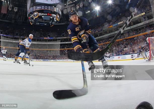 Nathan Beaulieu of the Buffalo Sabres reaches for the puck along the boards during the second period of an NHL game against the St. Louis Blues on...