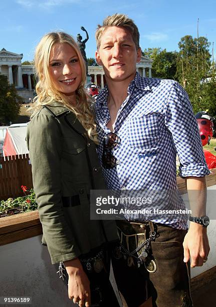 Bastian Schweinsteiger of Bayern Muenchen and girlfriend Sarah Brandner attend the Oktoberfest beer festival at the Kaefer Wiesnschaenke tent on...