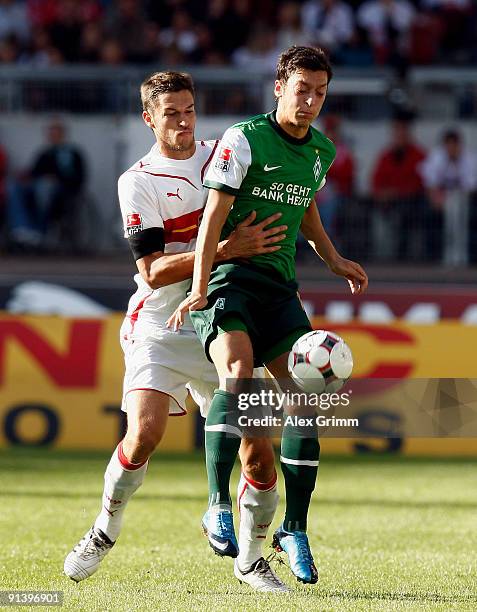 Mesut Oezil of Bremen is challenged by Matthieu Delpierre of Stuttgart during the Bundesliga match between VfB Stuttgart and SV Werder Bremen at the...