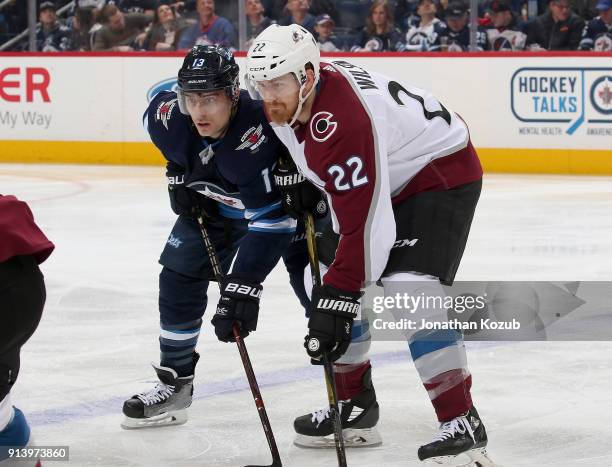 Brandon Tanev of the Winnipeg Jets and Colin Wilson of the Colorado Avalanche get set for a third period face-off at the Bell MTS Place on February...