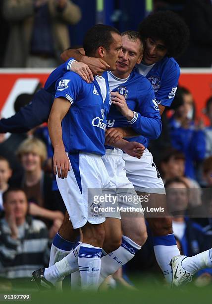 Leon Osman of Everton is congratulated by team mates Tony Hibbert and Marouane Fellaini after scoring his team's first goal during the Barclays...