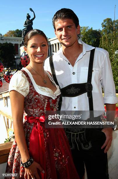 Bayern Munich's striker Mario Gomez and his girlfriend Silvia Meichel, dressed in traditional Bavarian clothes, pose in a beer tent at the...