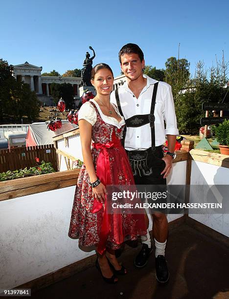 Bayern Munich's striker Mario Gomez and his girlfriend Silvia Meichel, dressed in traditional Bavarian clothes, pose in a beer tent at the...