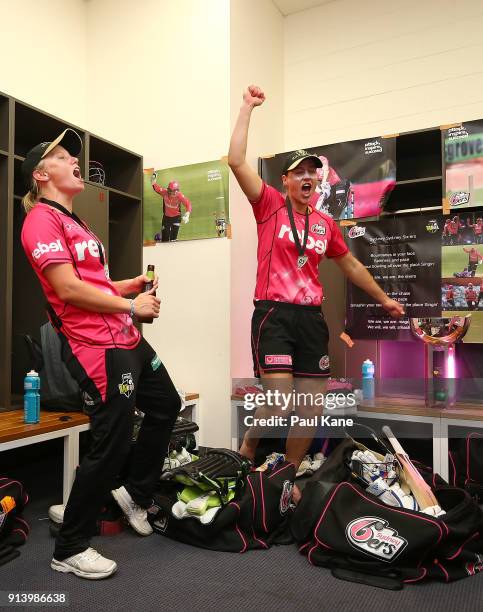 Alyssa Healy and Ellyse Perry of the Sixers sing the team song after winning the Women's Big Bash League final match between the Sydney Sixers and...