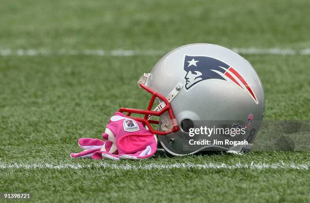 Randy Moss of the New England Patriots leaves his pink gloves, worn to support Breast Cancer Awareness, on the field before a game with the Baltimore...