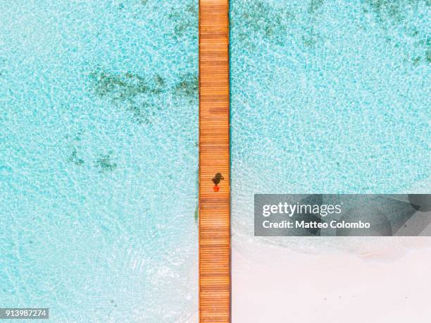 Overhead view of woman walking on jetty, Maldives