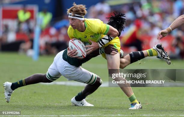 Australia's Ben O'Donnell looks to offload in the tackle during the World Rugby Sevens Series semi final match between Australia and South Africa at...