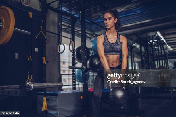 confident young woman exercising in gym - body building stock pictures, royalty-free photos & images