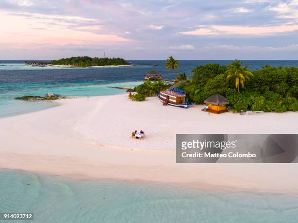 aerial of couple eating dinner on the beach, maldives - dining overlooking water stock pictures, royalty-free photos & images