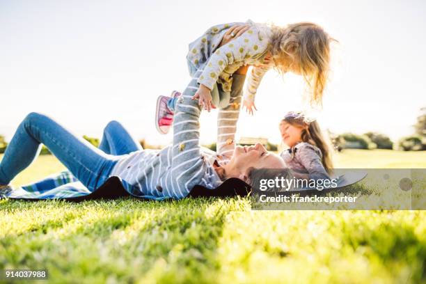 glückliche familie viel spaß im park - baby spielt mit essen stock-fotos und bilder