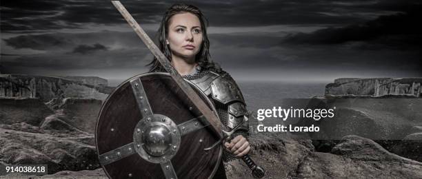 zwaard zwaaien viking warrior donkere harige vrouw in wilde hoogland platteland - armoured stockfoto's en -beelden