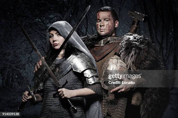 macho y hembra par guerrero de viking en campo montaña salvaje - armoured fotografías e imágenes de stock