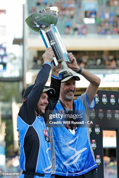 Travis Head and Jason Gillespie, coach of the Strikers hold asloft the trophy after winning the Big Bash League Final match between the Adelaide...