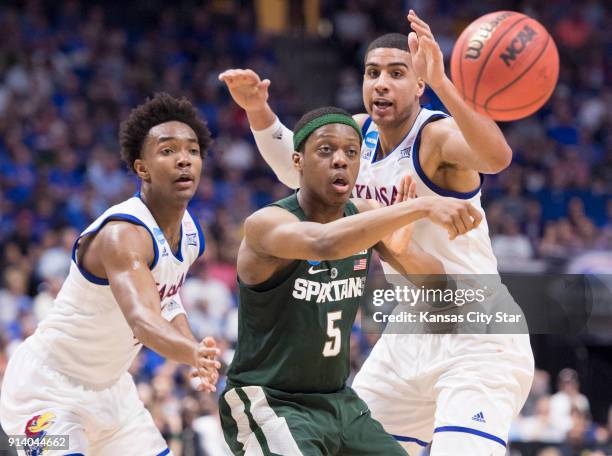 Kansas guard Devonte' Graham and forward Landen Lucas watch as Michigan State guard Cassius Winston squeezes a pass through in the first half of a...