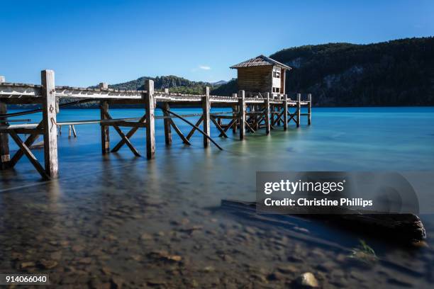 a pier in a quiet lake on a sunny day in the argentinian lake district - villa-la-angostura stockfoto's en -beelden