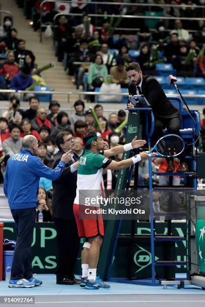 Team captain Corrado Barazzutti and Fabio Fognini of Italy argue with the chair umpire in his singles match against Yuichi Sugita of Japan during day...