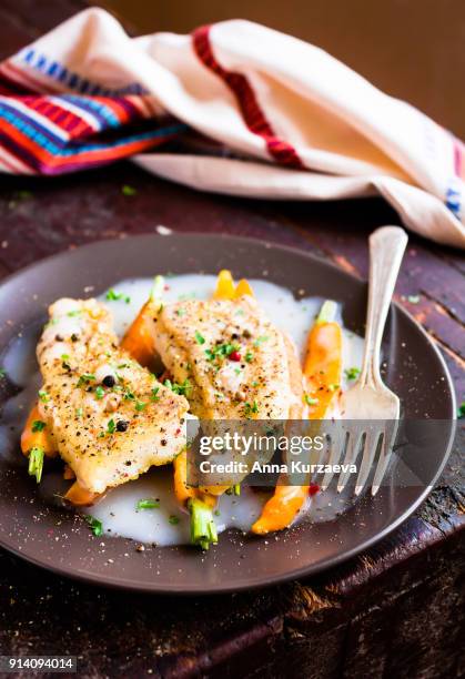 roasted white fish fillet with cream sauce and baby carrots on a plate, selective focus - peppercorn sauce stock pictures, royalty-free photos & images