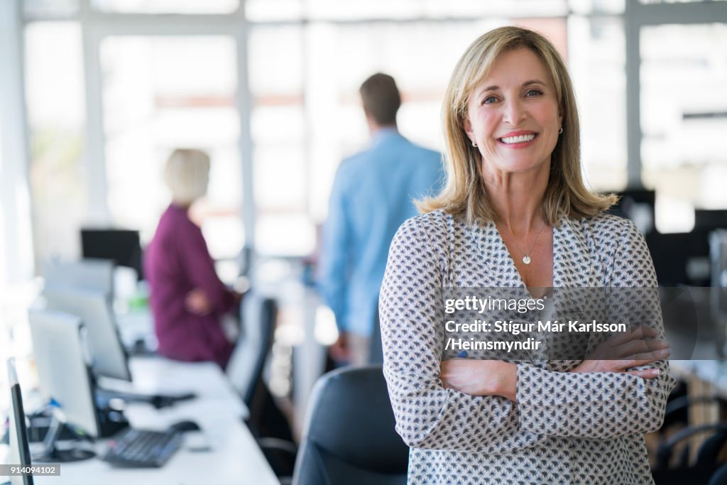 Mulher de negócios com os braços cruzados no escritório