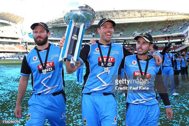 Michael Neser, Ben Laughlin and Jonathan Wells of the Strikers walk a lap of honour with the trophy after winning the Big Bash League Final match...