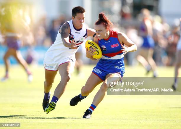 Jenna Bruton of the Bulldogs is tackled by Evie Gooch of the Dockers during the 2018 AFLW Round 01 match between the Western Bulldogs and the...