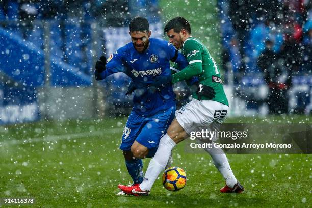 Jorge Molina of Getafe CF competes for the ball with Ezequiel Munoz during the La Liga match between Getafe CF and Deportivo Leganes at Coliseum...