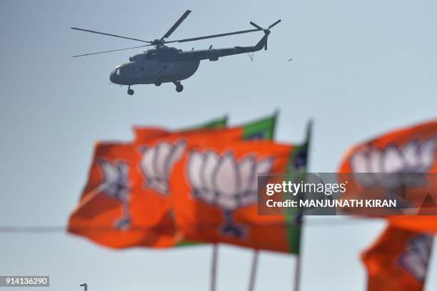 An Indian Air Force helicopter carrying Indian Prime Minister Narendra Modi is seen over Bharatiya Janata Party flags before a gathering...