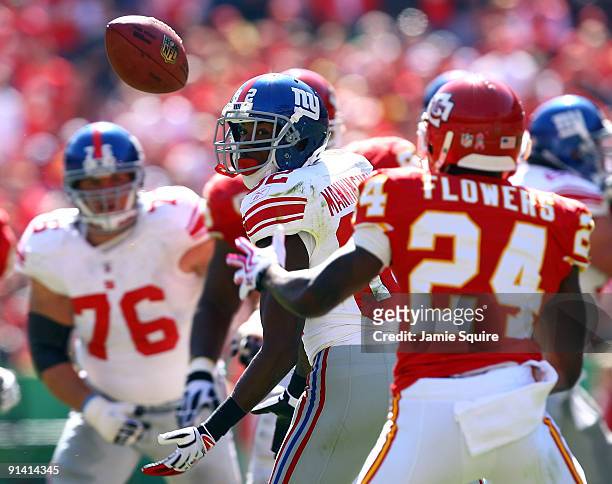 Receiver Mario Manningham of the New York Giants watches as the ball hits off his pads and into the arms of Brandon Flowers of the Kansas City Chiefs...