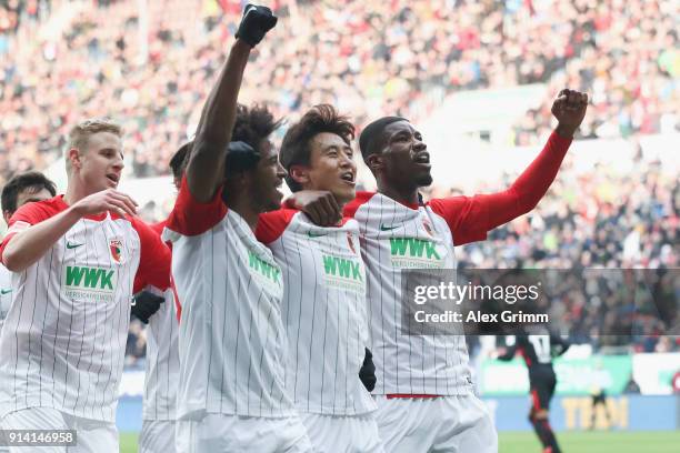 Ja-cheol Koo of Augsburg celebrates his team's first goal with team mates Kevin Danso and Caiuby during the Bundesliga match between FC Augsburg and...