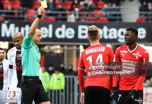 French referee Ruddy Buquet gives a yellow card to Rennes' Malian defender Hamari Traore during the L1 football match between Rennes and Guingamp, on...